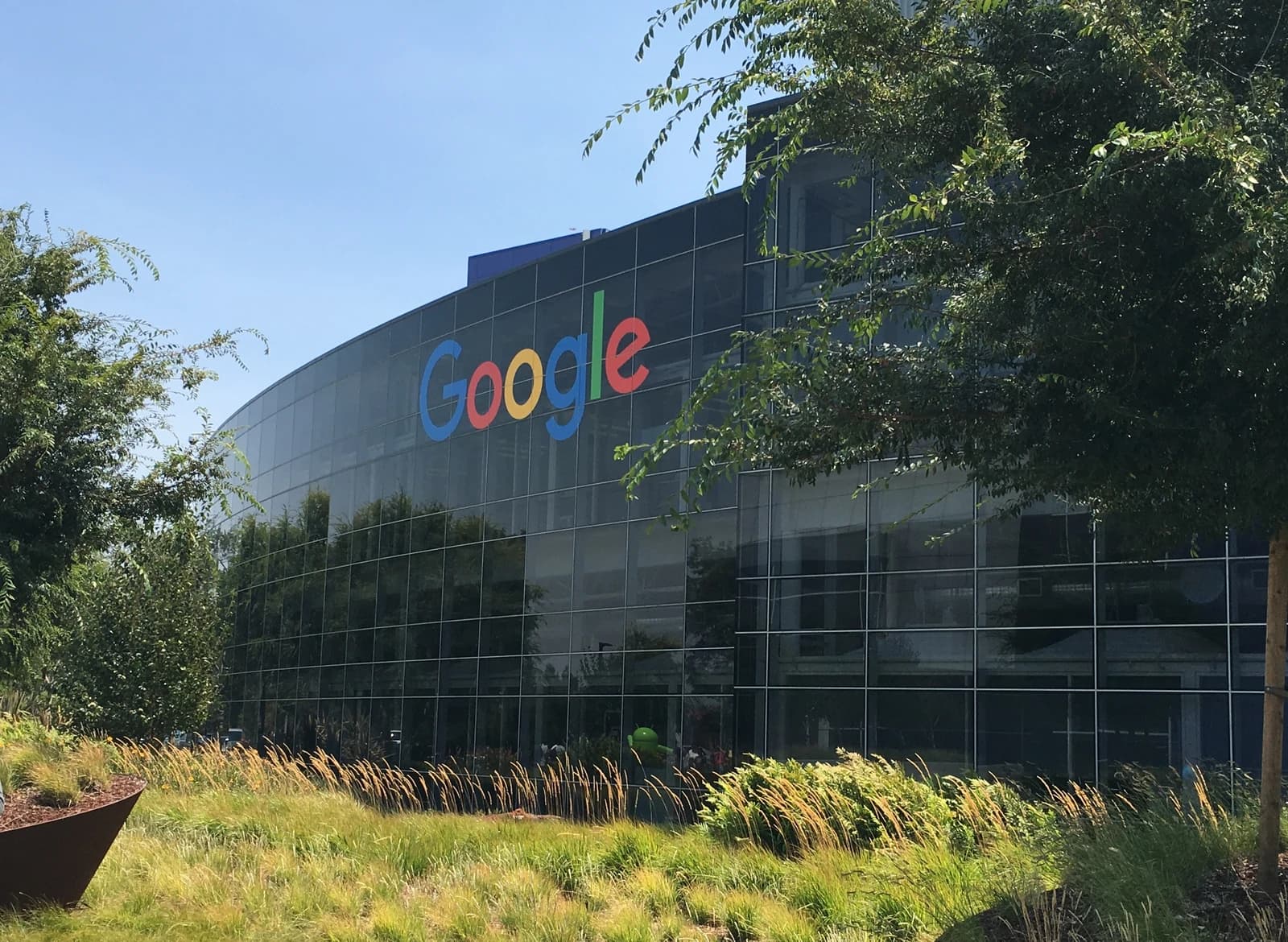 Colorful Google logo displayed on the glass exterior of a large office building.