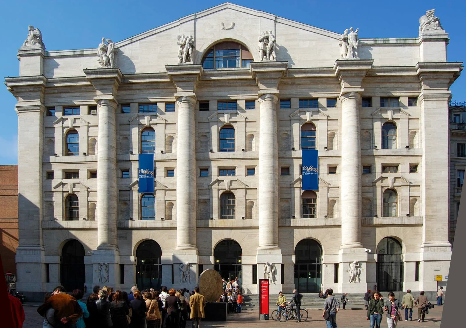 Palazzo Mezzanotte, the Milan Stock Exchange building, with people walking outside.