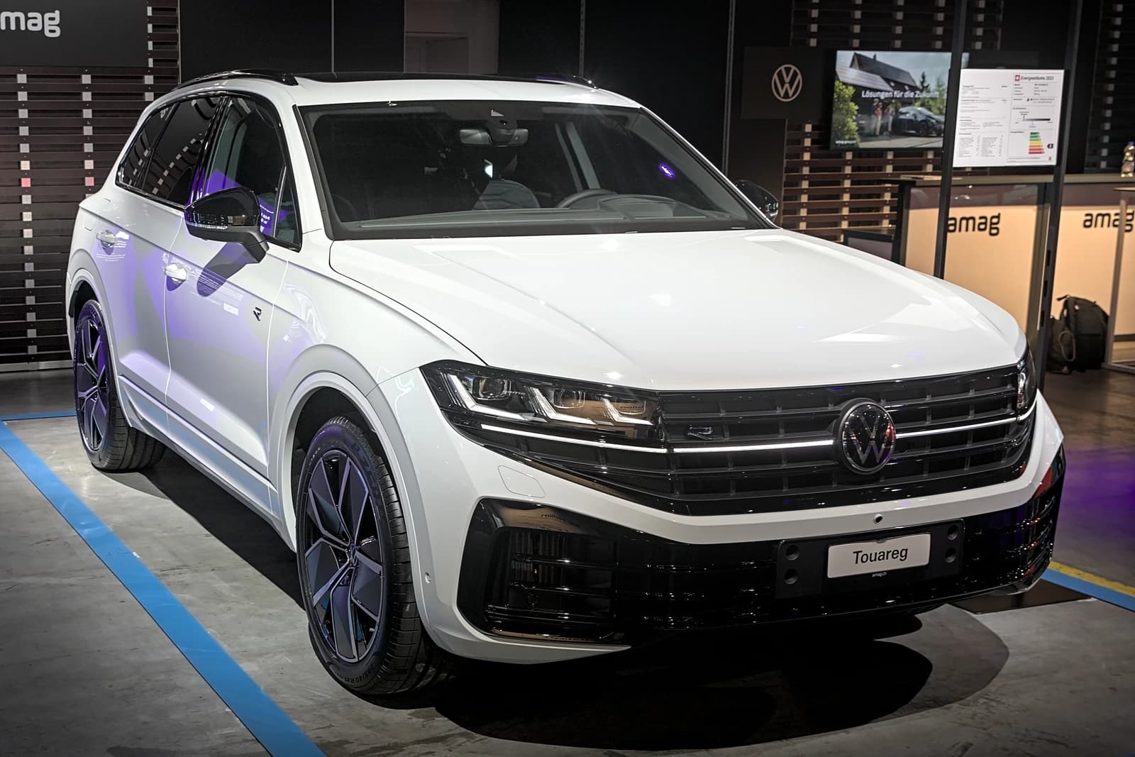 A white 2024 Volkswagen Touareg R is displayed at Auto Zürich 2023.