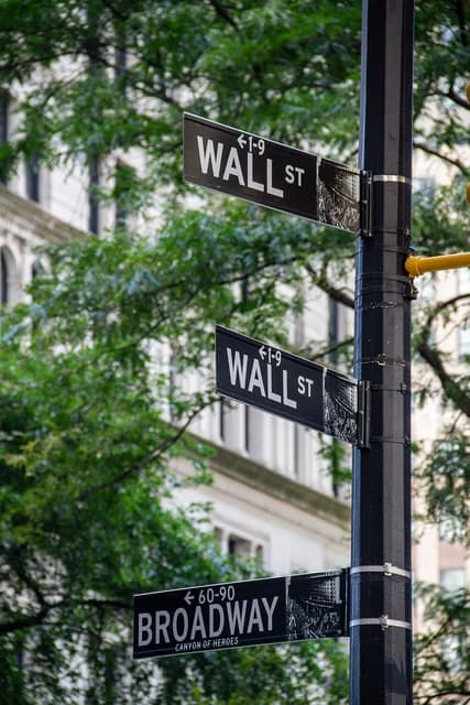 Wall Street and Broadway street signs on a pole in Manhattan, New York City.