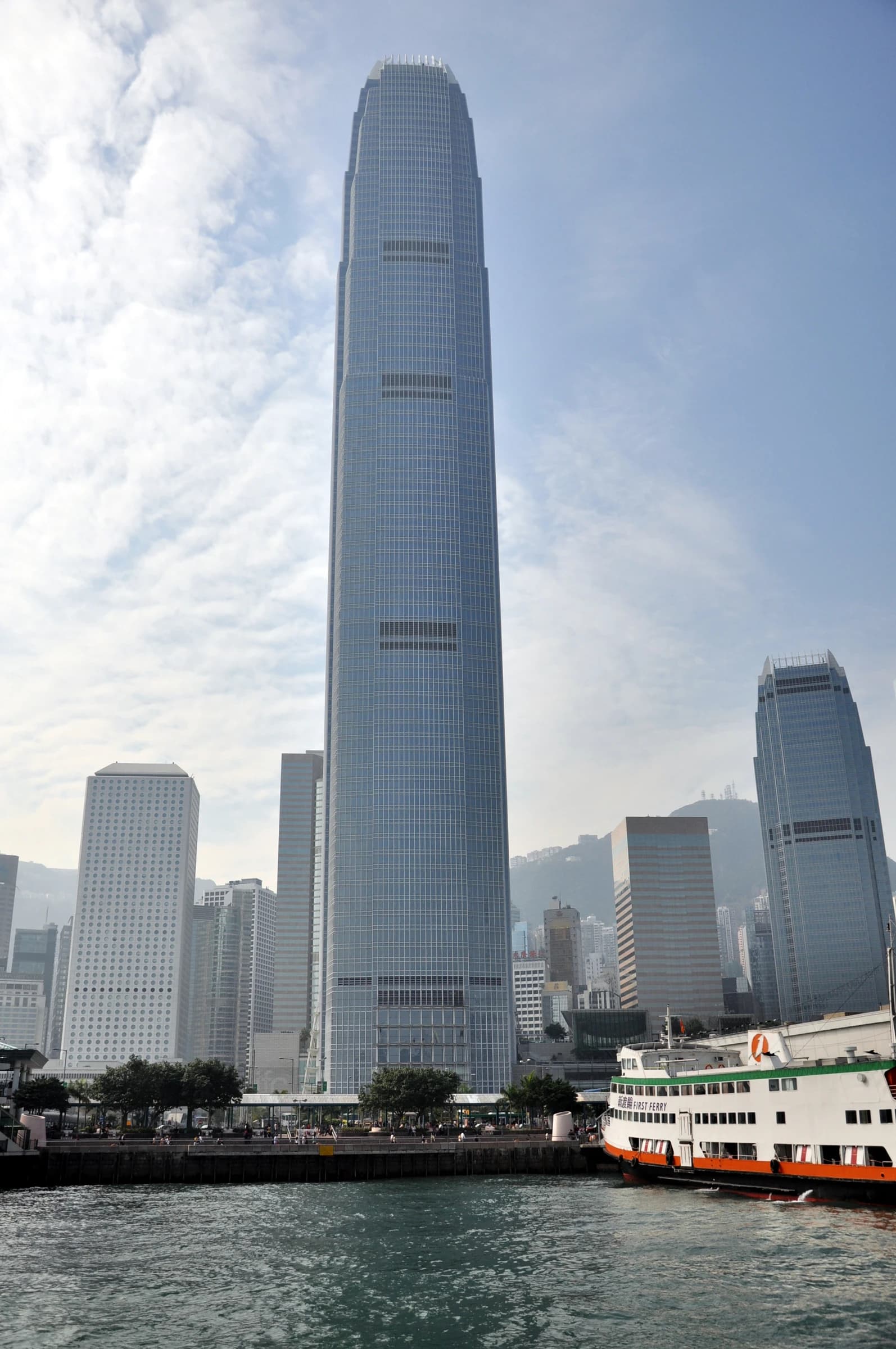 The Two International Finance Centre in Hong Kong with a ferry docked nearby.