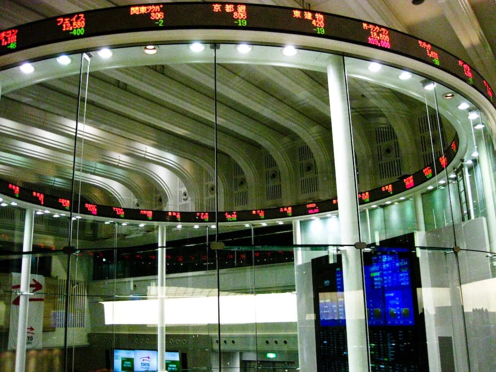 Interior view of the Tokyo Stock Exchange with a curved digital ticker display.