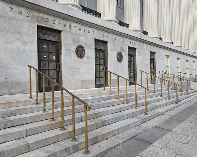 Exterior view of the Department of the Treasury building with steps and columns.