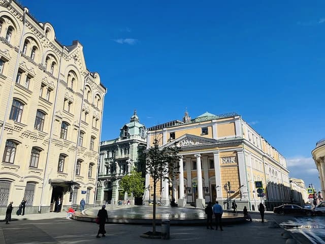 People walk past the classical architecture of the Moscow Exchange building in Russia.