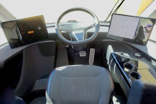 Interior view of Tesla Semi electric truck cockpit with two digital screens.