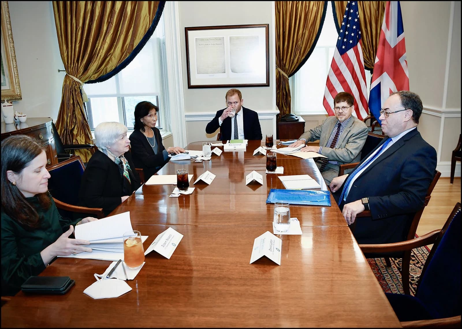 Janet Yellen and Andrew Bailey sit at a large wooden conference table with others.