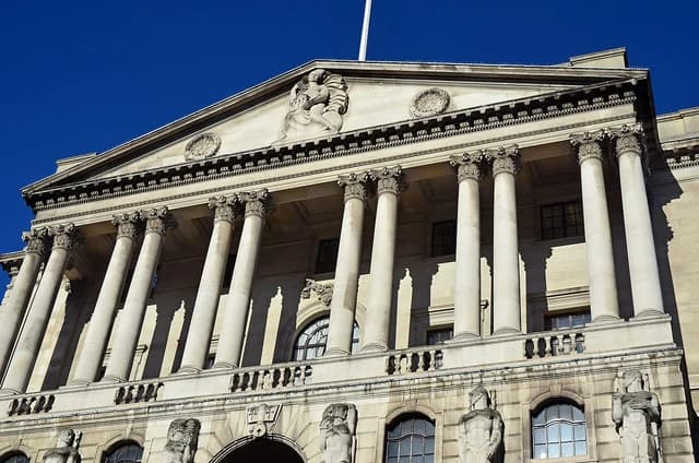 Exterior facade of the Bank of England building with large columns and statues.