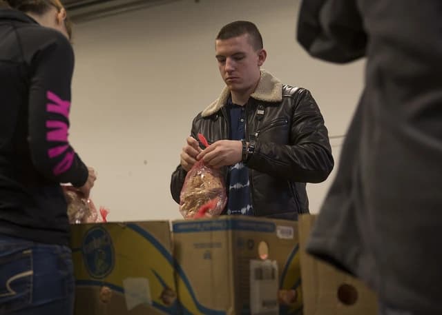 Marine or sailor volunteers packaging food items at The Greater Boston Food Bank.
