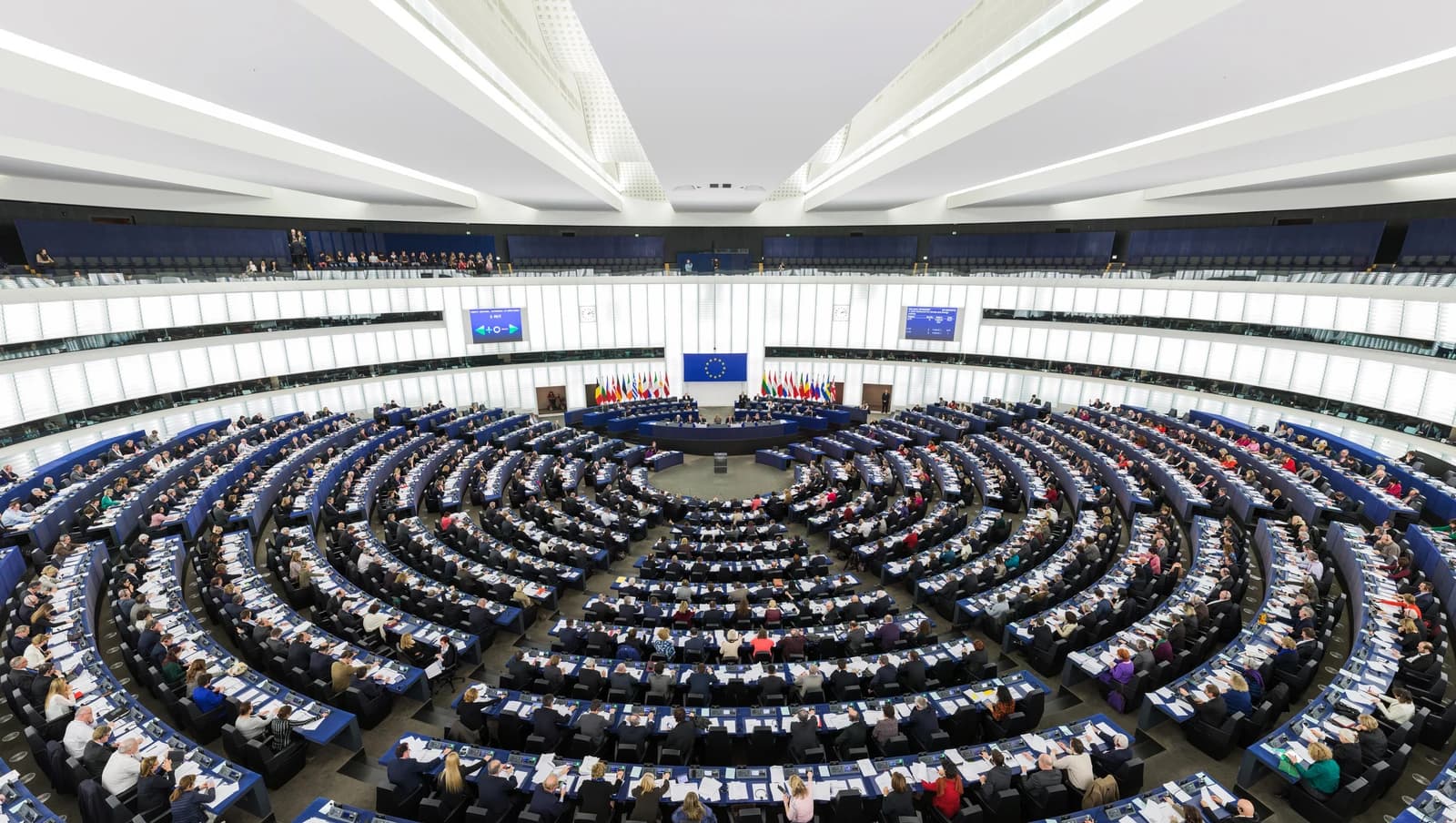 European Parliament members seated in the Hemicycle chamber during a session.