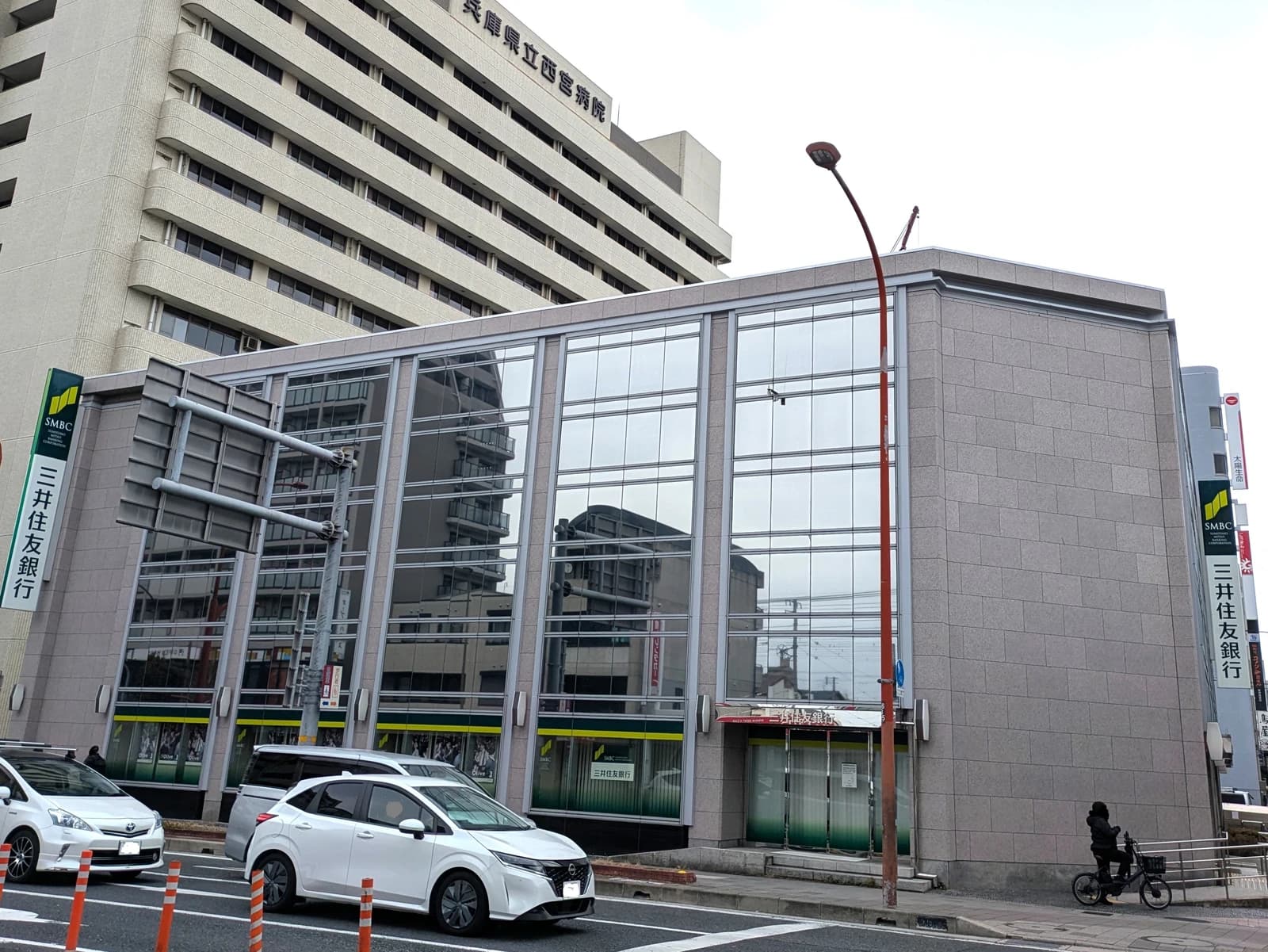Sumitomo Mitsui Banking Corporation Nishinomiya and Koto branches building with street and cars.