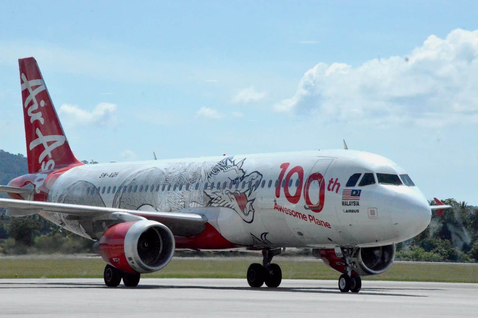 An AirAsia Airbus A320 aircraft with special livery taxiing on a runway.
