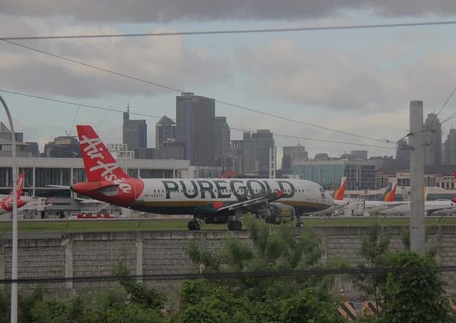 An AirAsia aircraft with 'Puregold' branding parked on an airport tarmac.