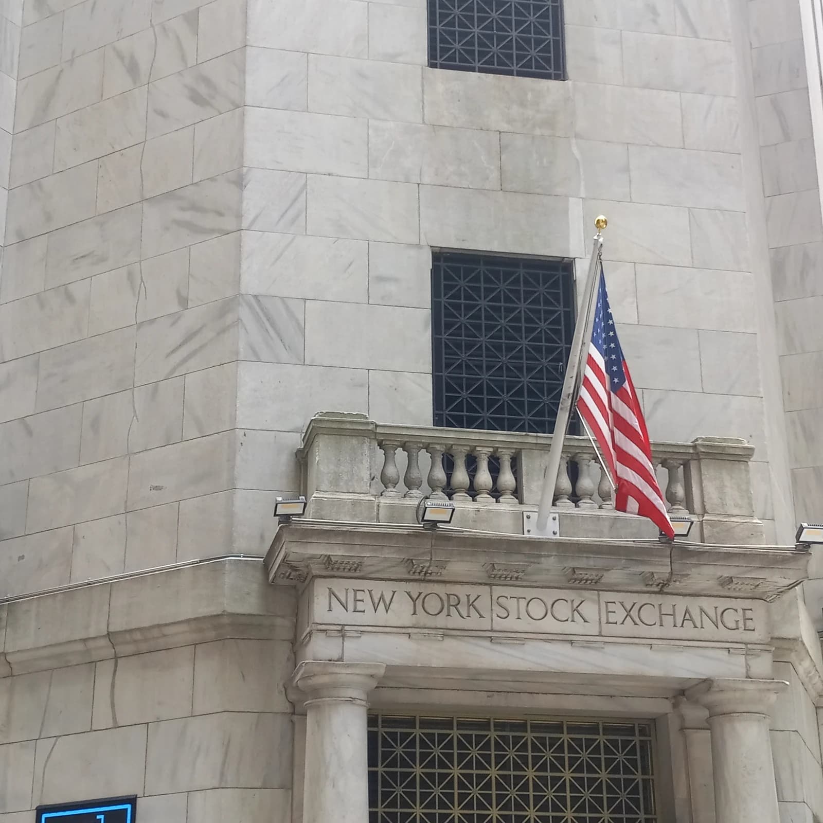 Exterior of the New York Stock Exchange building with an American flag.
