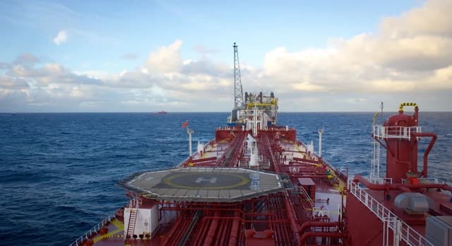 Oil tanker approaching a Floating Production Storage and Offloading (FPSO) unit at sea.
