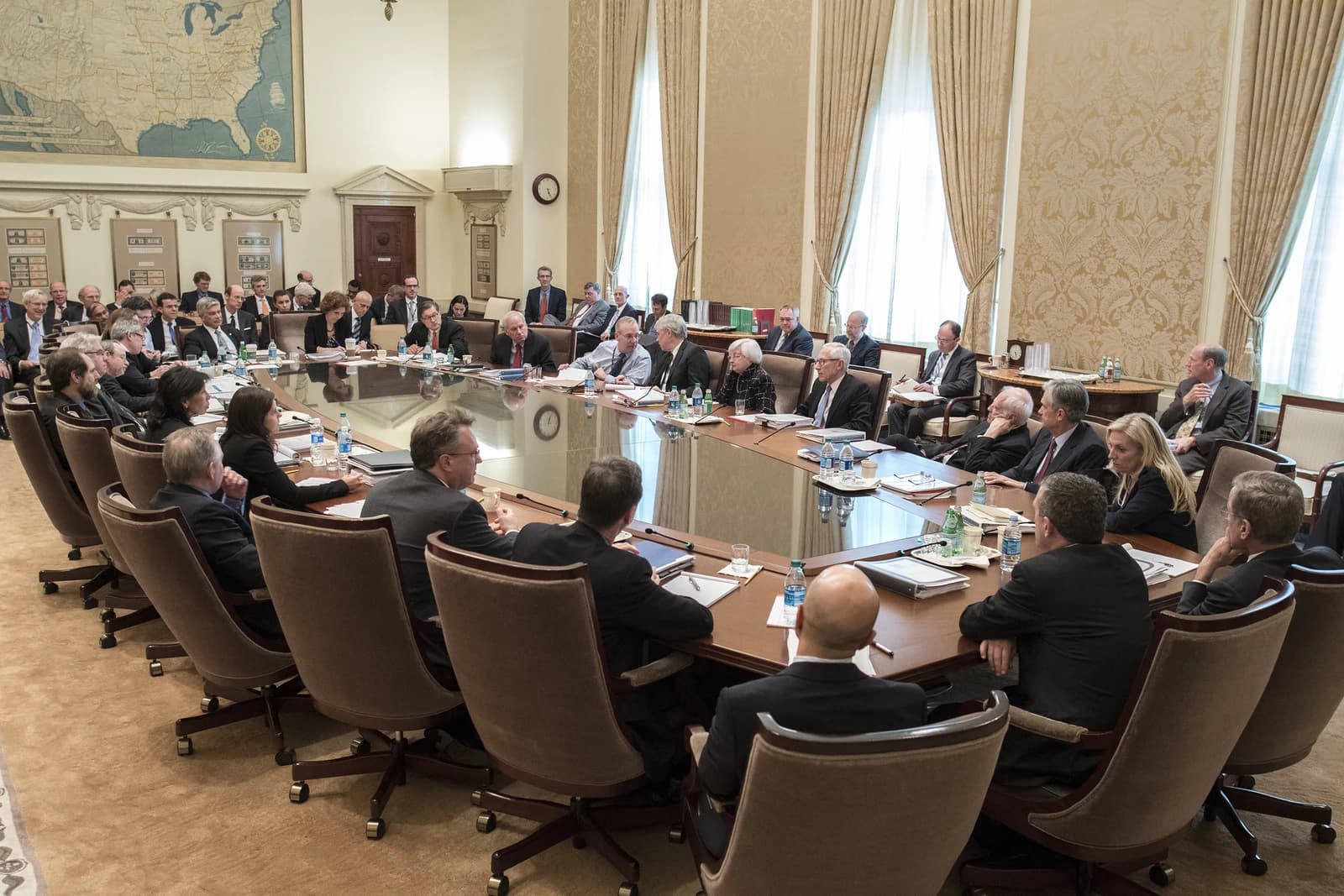 Federal Open Market Committee members sitting around a large conference table in Washington D.C.