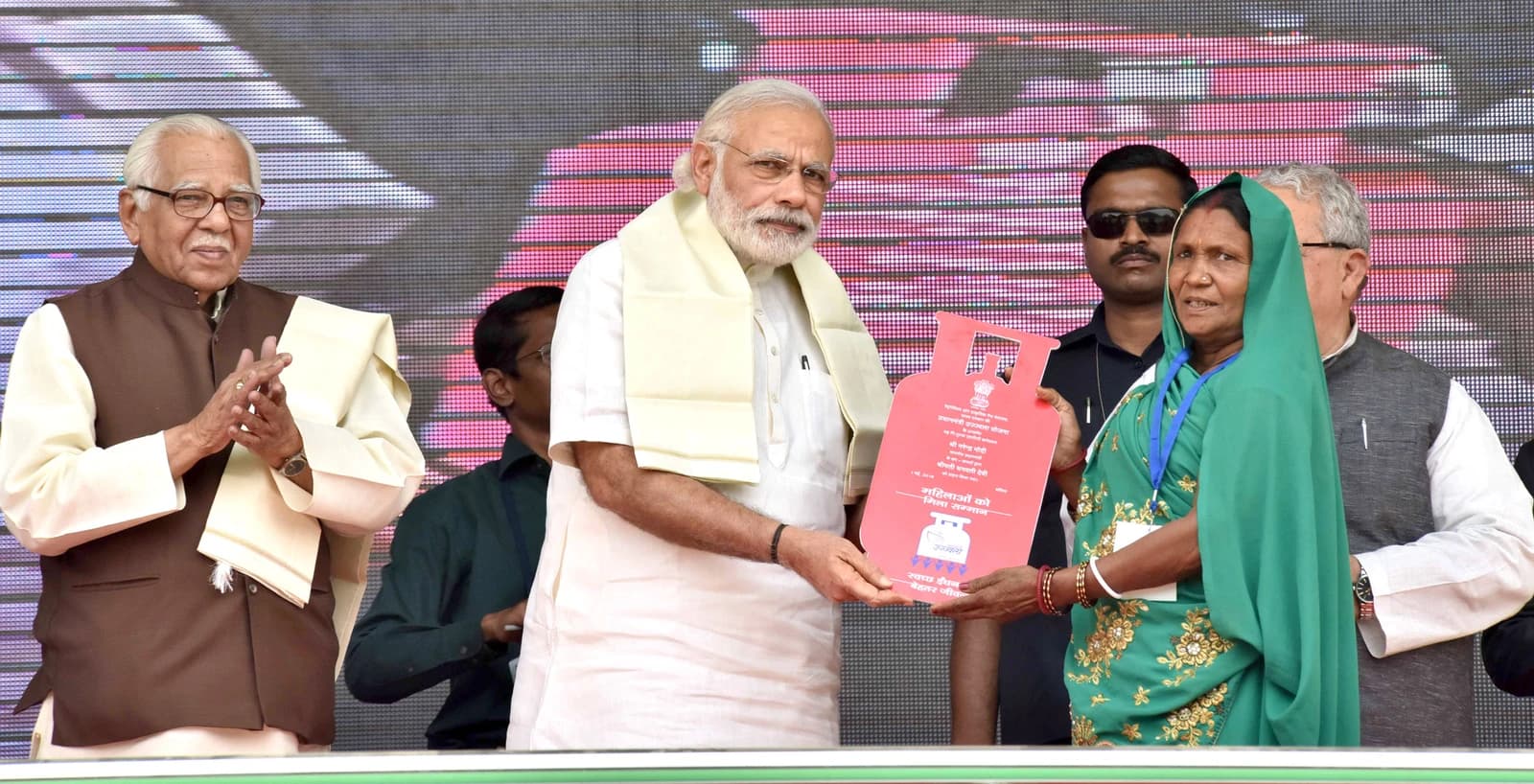 Prime Minister Narendra Modi distributing a free LPG connection to a woman beneficiary.