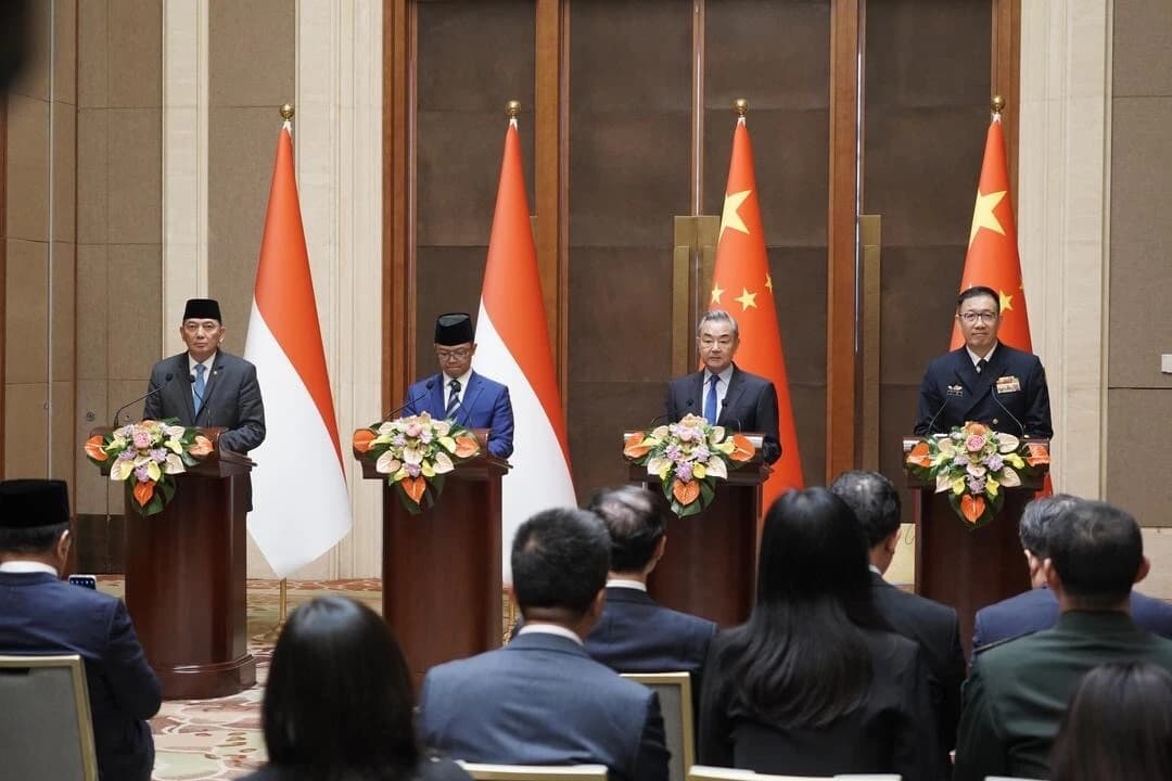 Chinese and Indonesian Foreign Ministers and Defense Ministers stand behind podiums with flags.