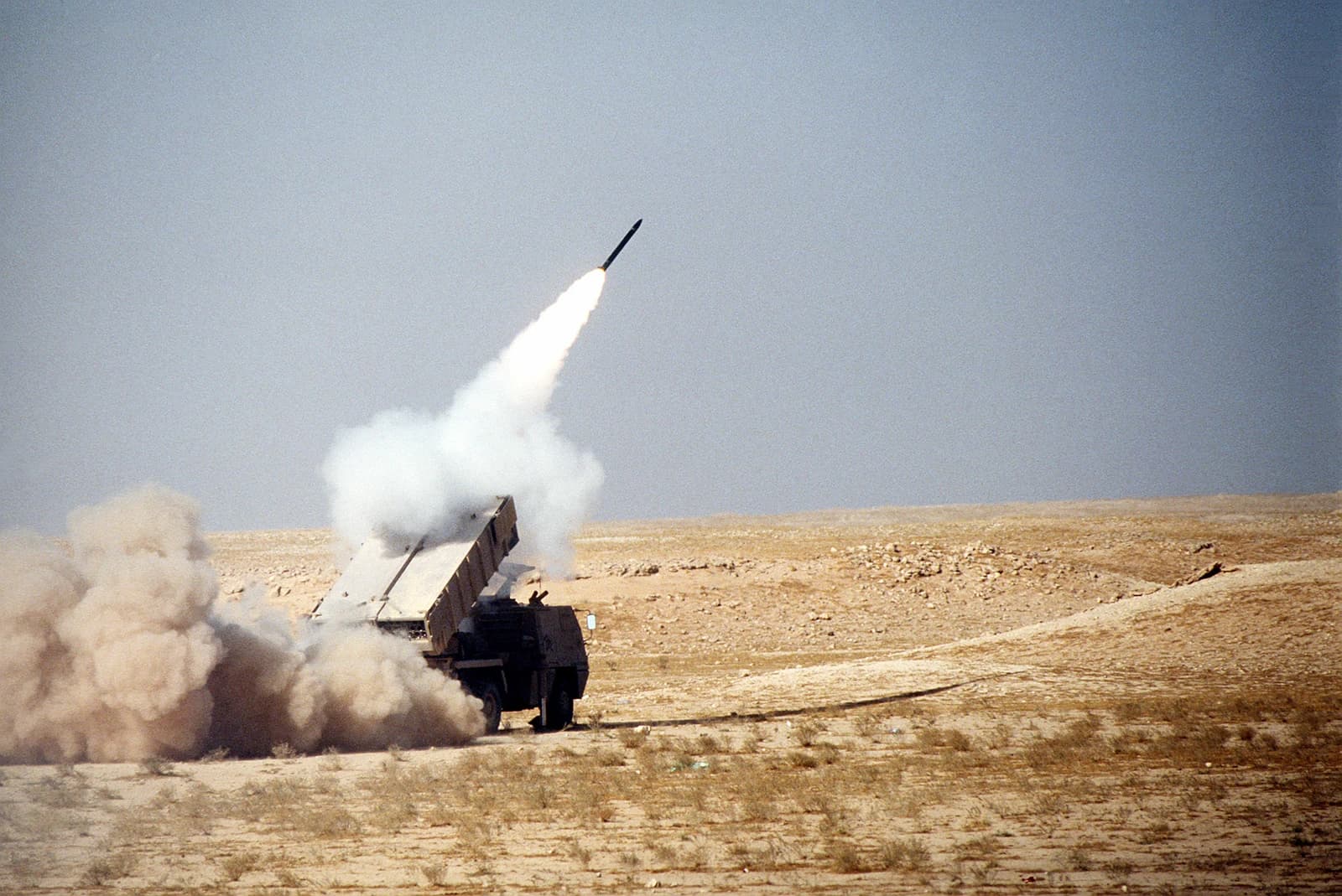 Military rocket launching from an ASTROS-II MLRS in a desert area.