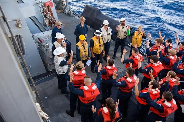 US Navy sailors on the USS Mason stand on deck during replenishment-at-sea operations in the Red Sea.