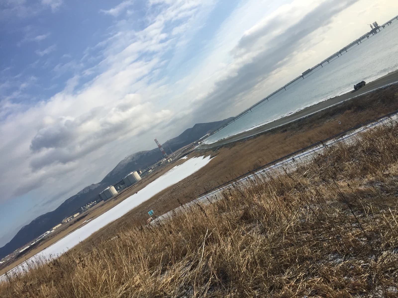 Port Prigorodnoye on Sakhalin Island with LNG tanks and industrial facilities by the sea.