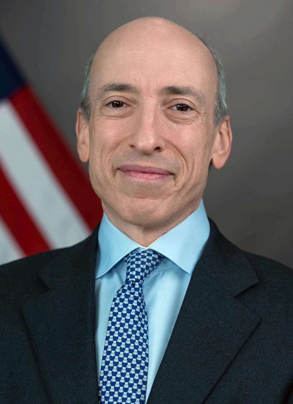 Gary Gensler, SEC Chair, in an official portrait against an American flag.