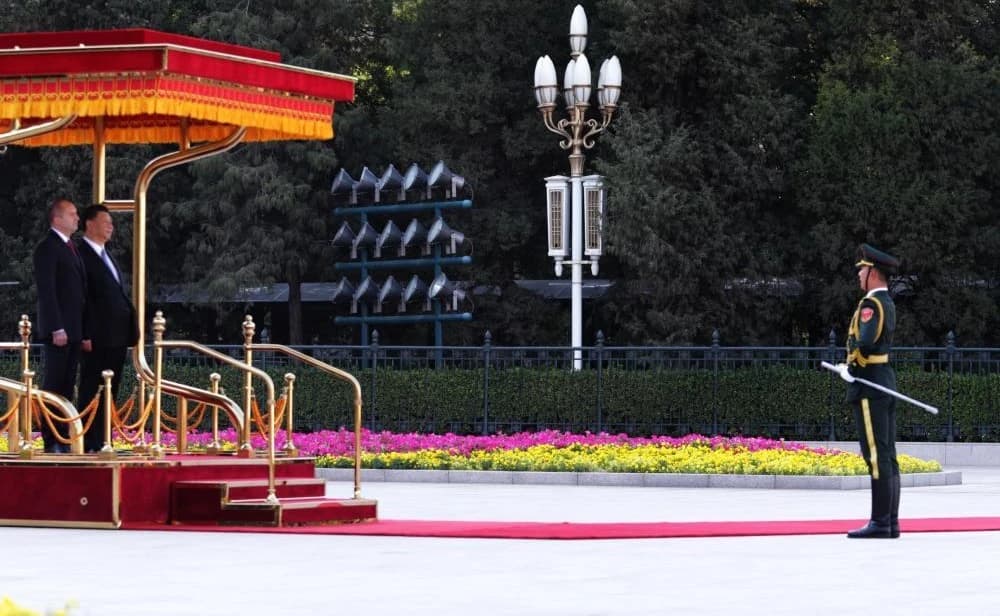 Chinese President Xi Jinping and Bulgarian President Rumen Radev stand on a red carpet reviewing ceremony.
