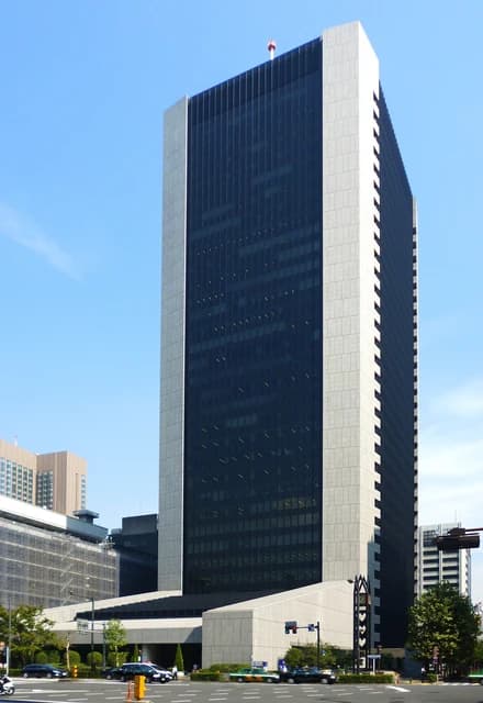 The Mizuho Bank Head Office, a tall building with dark windows and light-colored siding, in Tokyo.