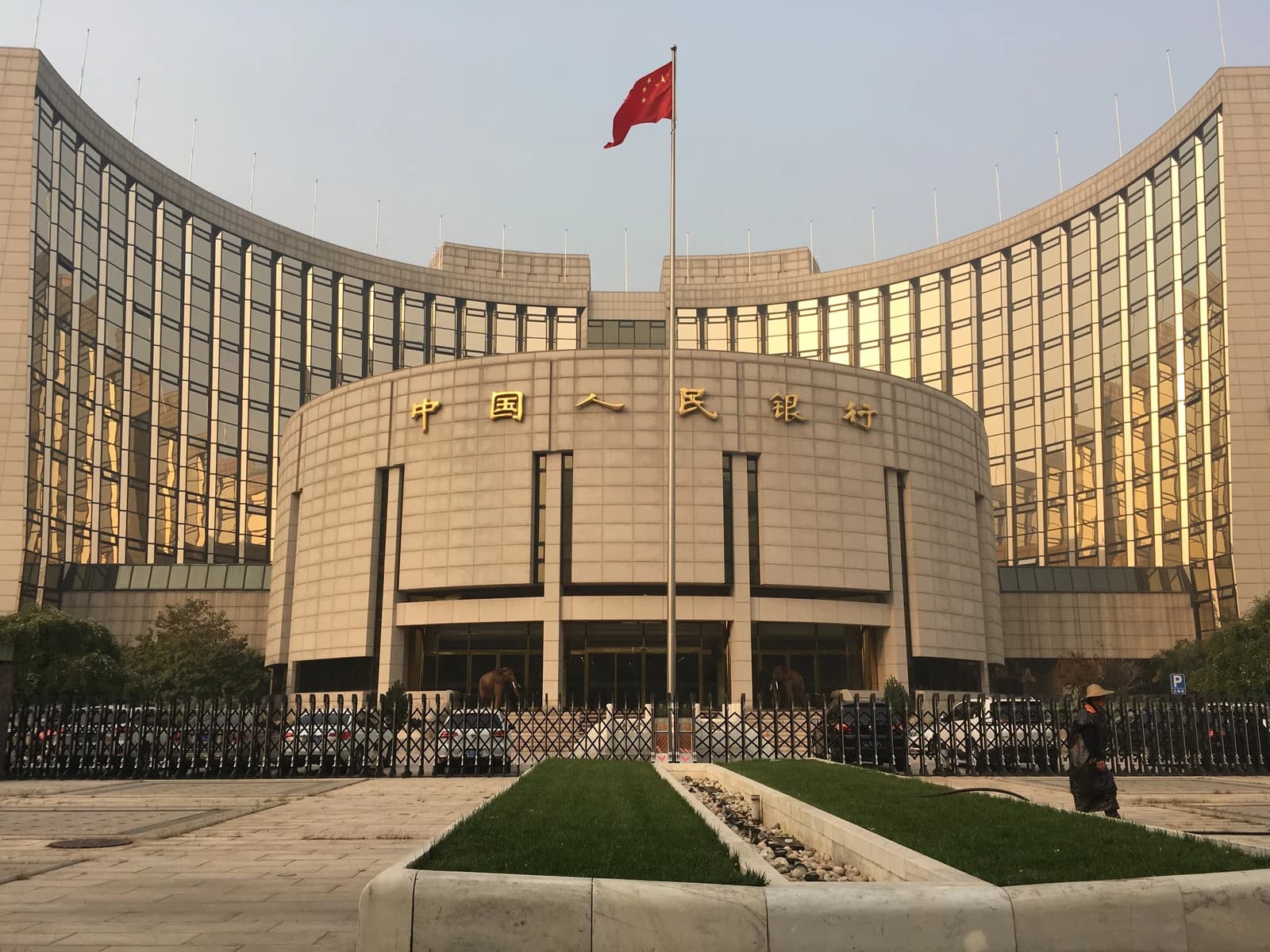 People's Bank of China Headquarters building in Beijing with a Chinese flag flying.
