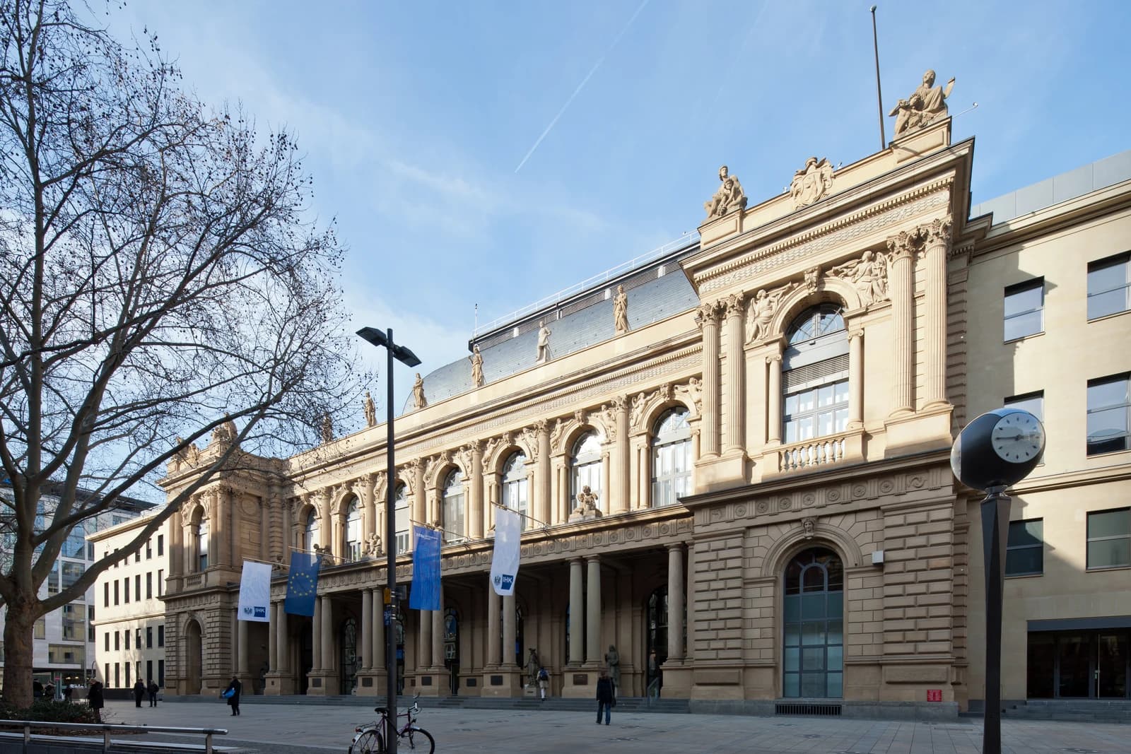 Exterior view of the ornate Frankfurt Stock Exchange building under a blue sky.