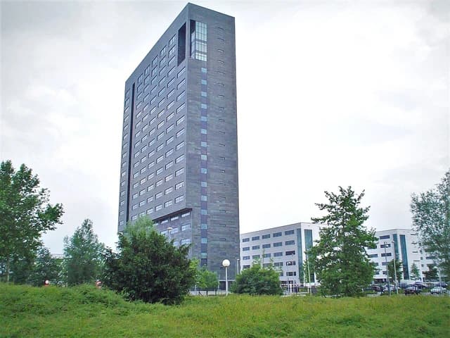 Modern high-rise building with dark facade, part of ASML headquarters.