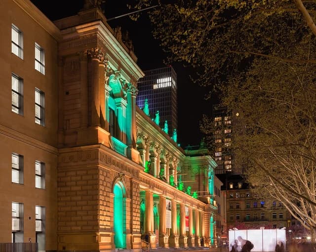 Börse Frankfurt stock exchange building illuminated with green and orange lights at night.
