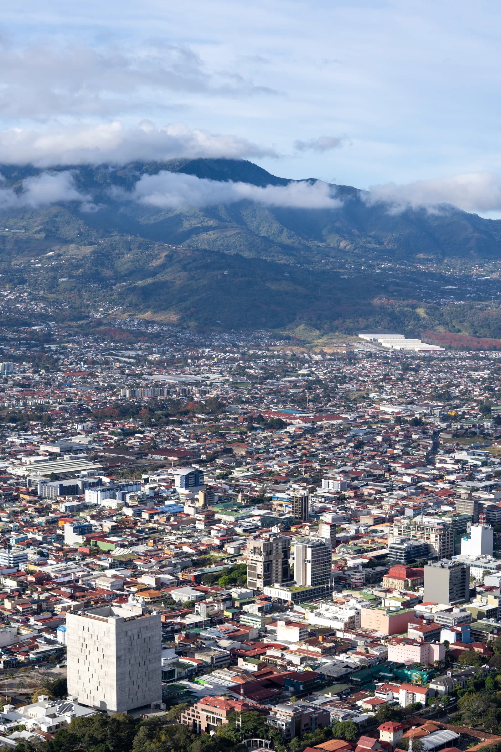 Aerial view of San José, Costa Rica, showing densely packed city buildings and mountains.