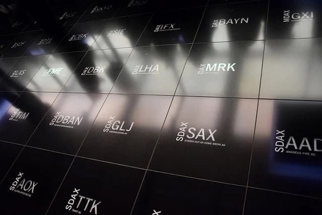 Floor of the Frankfurt Stock Exchange displaying various company tickers and stock indices.