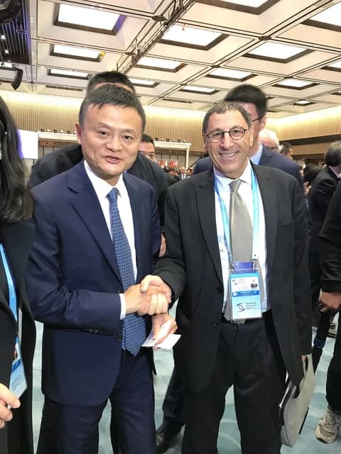 Jack Ma, founder of Alibaba, shaking hands with Yossi Dashti in an indoor setting.