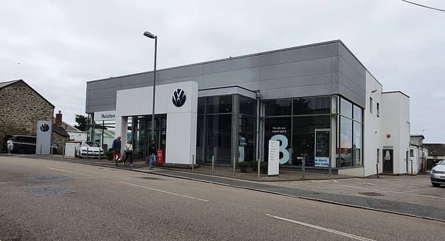 Exterior of a Volkswagen car dealership with a logo and signs.