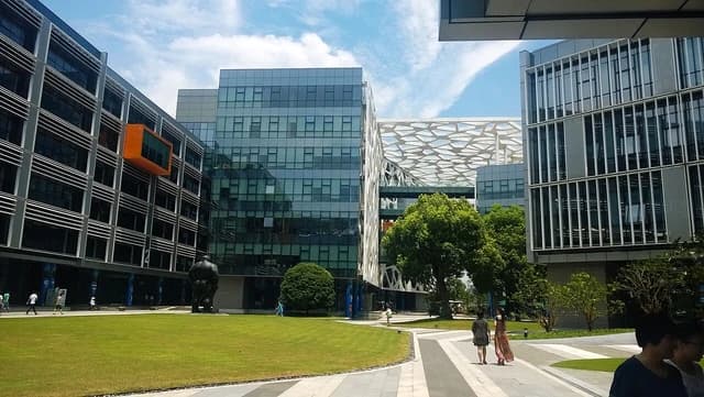 Modern office buildings and green lawns at the Alibaba Binjiang Park campus.