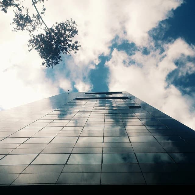 Building exterior of the Colombian Stock Exchange reflecting clouds and sky.