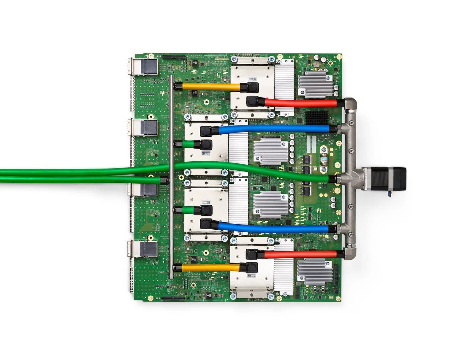An overhead view of a green circuit board with multiple processors and liquid cooling tubes.