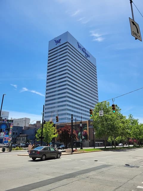 Kroger headquarters building with shopping cart logo under a clear blue sky.