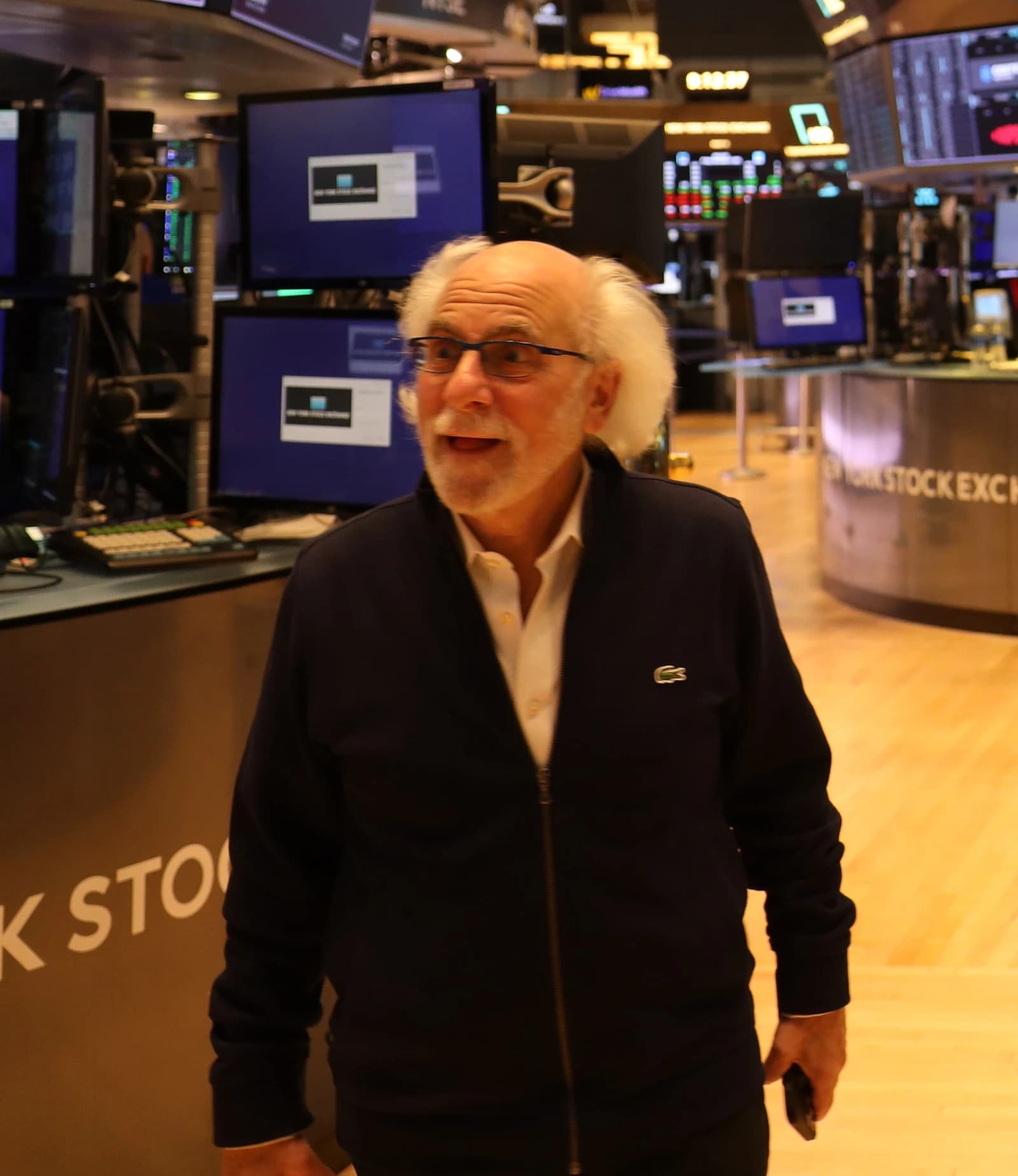Peter Tuchman, NYSE floor broker, wearing glasses and a jacket, on the trading floor.