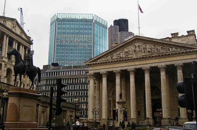 Exterior view of the Royal Exchange building in London, with classical columns and sculptures.