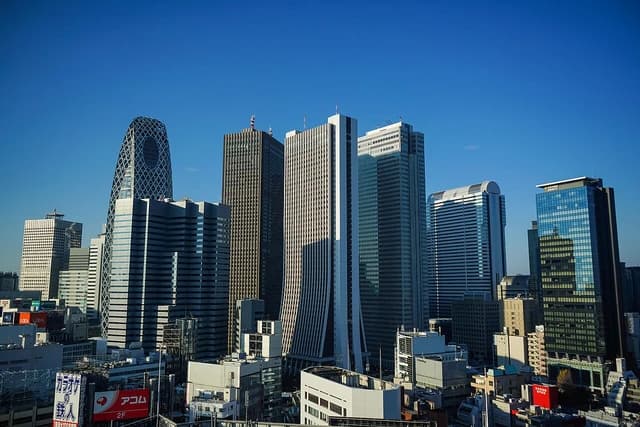 Shinjuku skyline with numerous modern buildings under a clear blue sky.