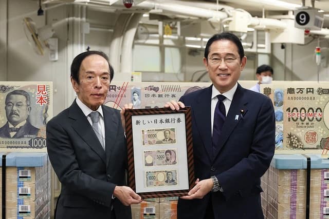 Japanese Prime Minister Fumio Kishida and Bank of Japan Governor Kazuo Ueda holding a framed display.