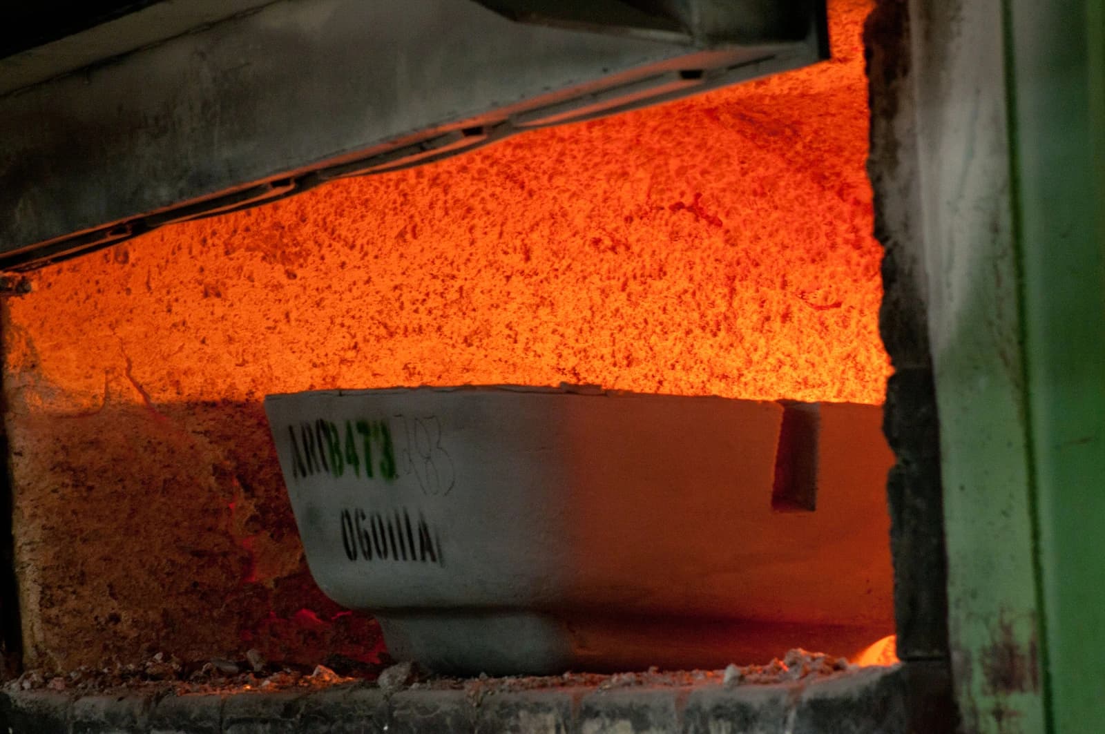 An industrial furnace glows with intense heat around metal ingots.