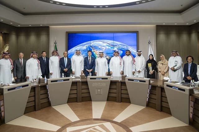 Group of men and women, including WIPO Director General and Saudi Minister of Investment, standing in a conference room.