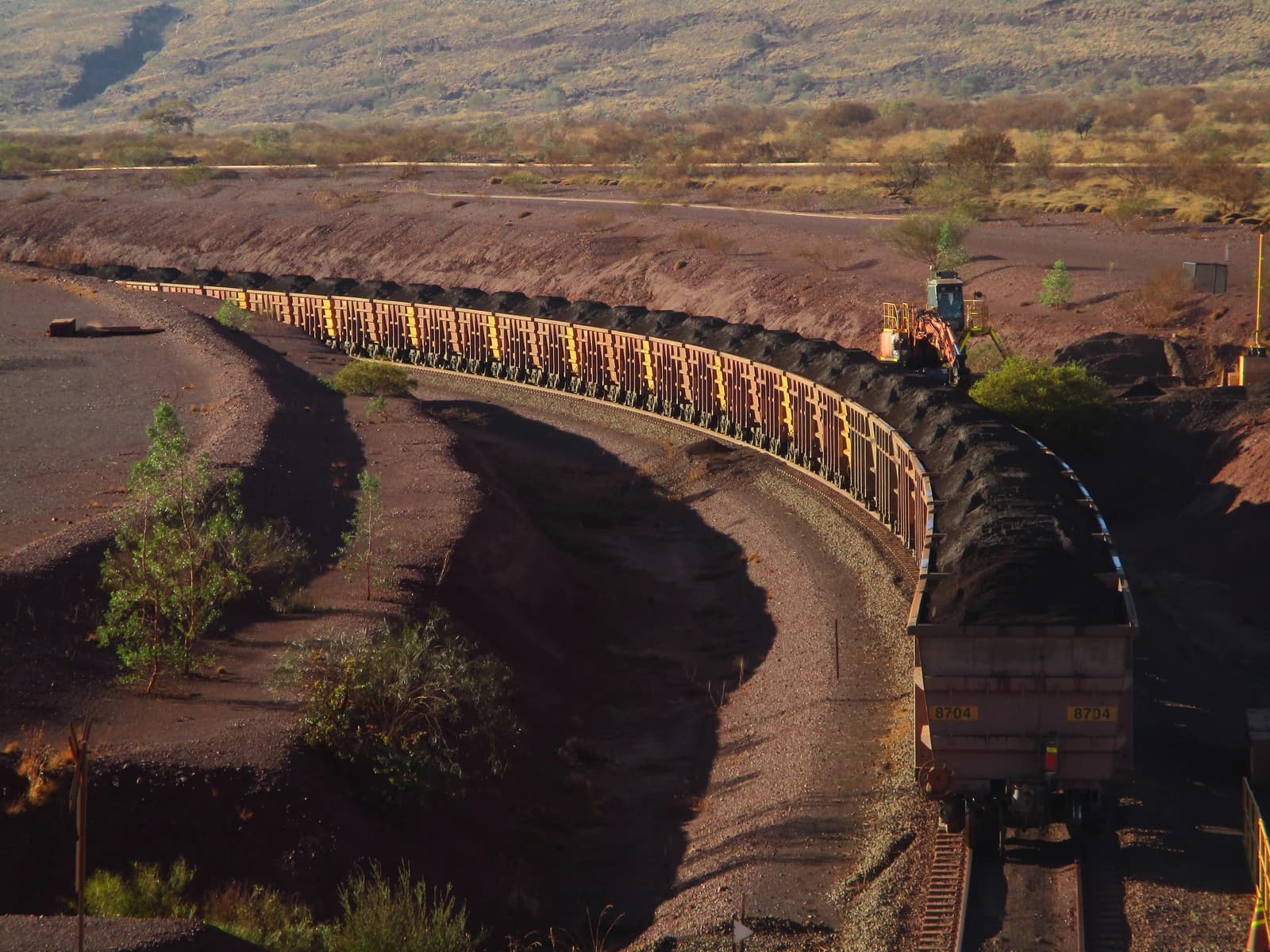 An iron ore train leaving the Brockman 4 mine, with wagons full of ore.