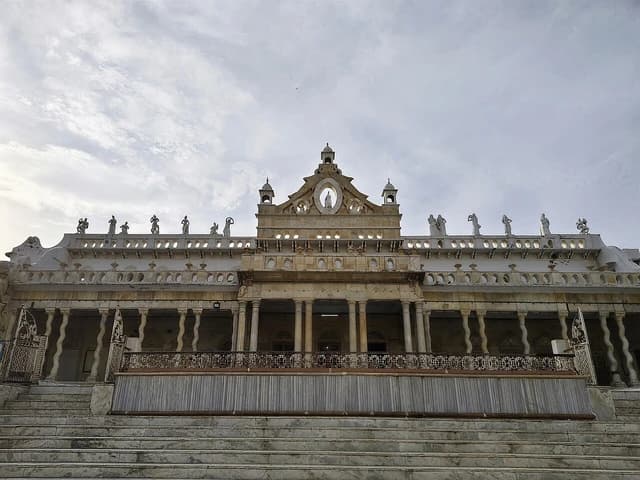 Exterior facade of the Shahji Temple in Vrindavan featuring intricate architecture and multiple statues on the roofline.