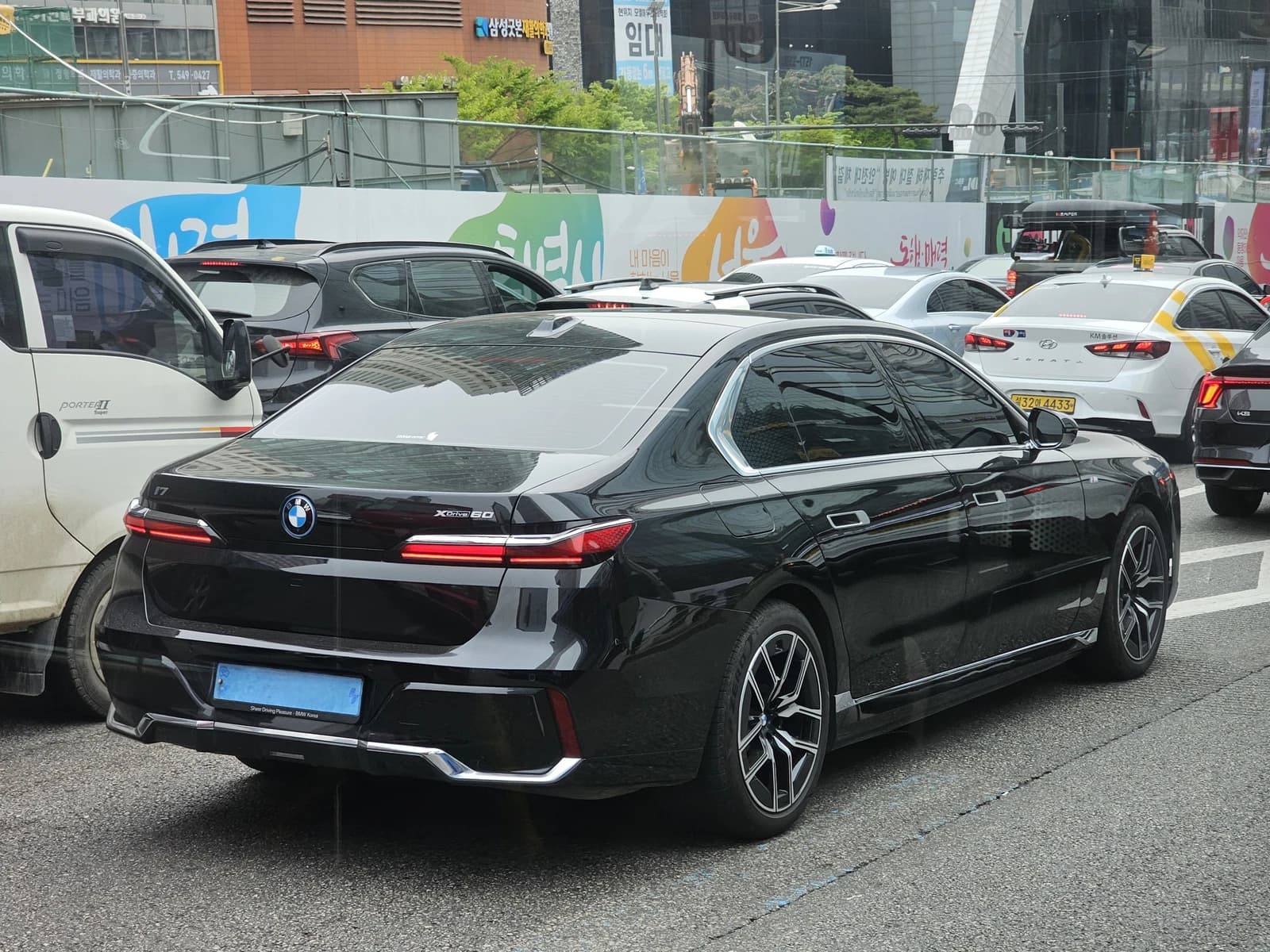 A black BMW i7 xDrive60 M Sport sedan on a city street.