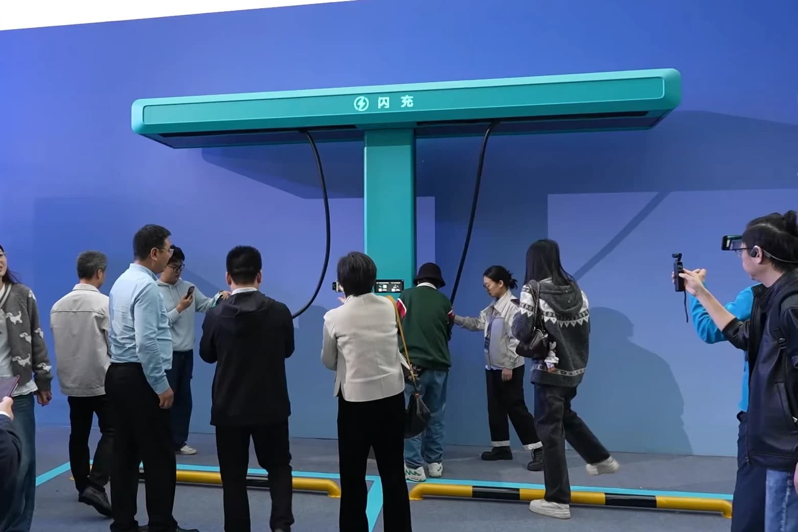 People observe a BYD Flash Charging 1500 kW charging station demo.