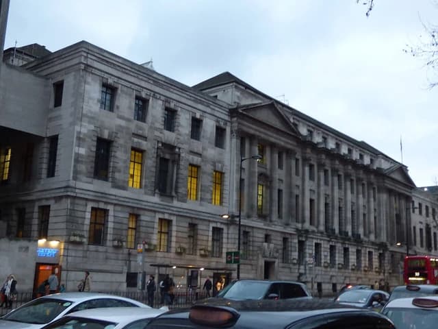 Camden Town Hall building with cars and people on a street in London.